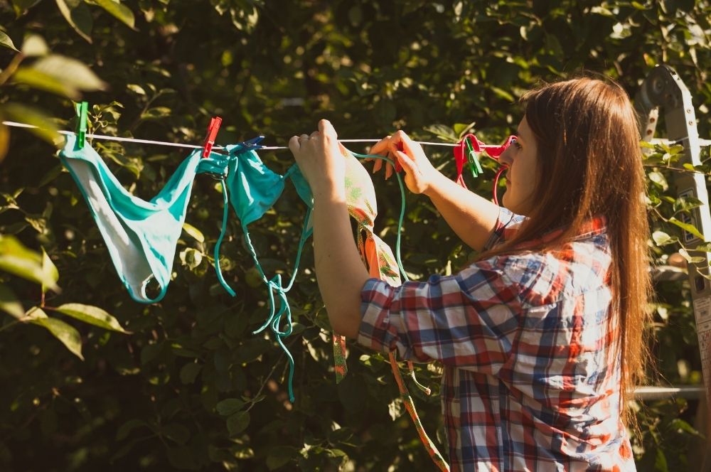 une femme qui étend des maillots de bain